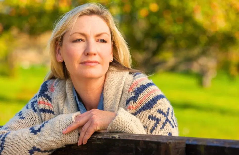 Middle-aged woman leaning on the fence. Managing Menopause. Brisbane Livewell Clinic