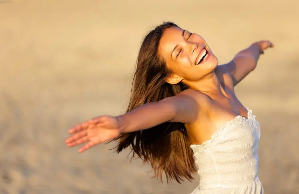 Woman enjoying time at the beach. What Causes Painful Periods. Brisbane Livewell Clinic