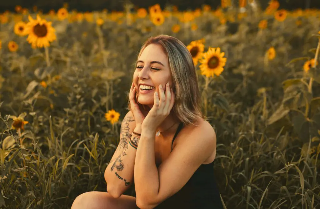 Woman sitting on a sunflower field. Food Intolerance or Food Allergies. Osteopath Support Hip or Pelvic Discomfort. Brisbane Livewell Clinic