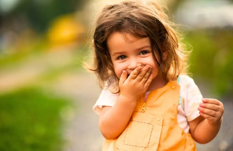 Little girl covers her mouth while laughing. Counselling Balmoral. Brisbane Livewell Clinic