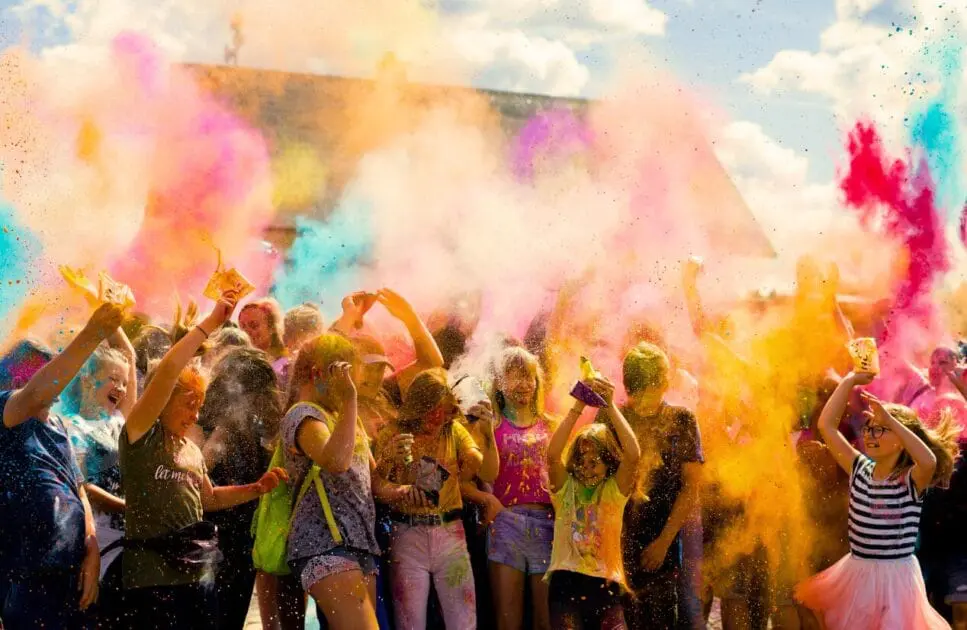 Cheerful crowd covered in colorful powder celebrating festive outdoor event. Counselling Carindale. Brisbane Livewell Clinic