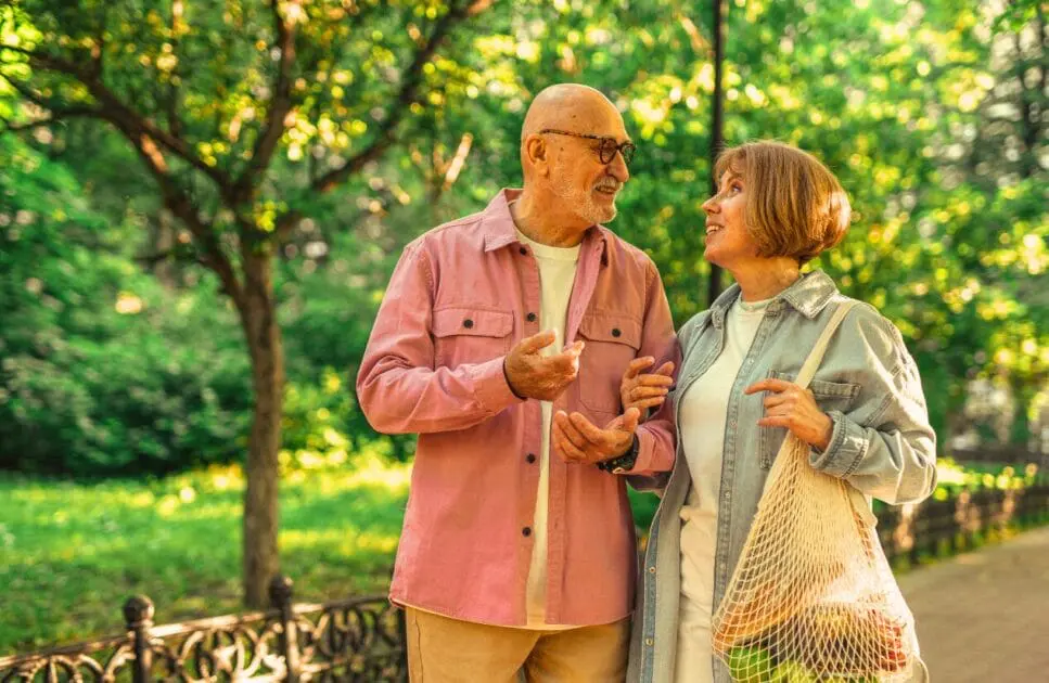 Middle-aged couple talking and walking in the park. Couples Therapy Counselling. Brisbane Livewell Clinic