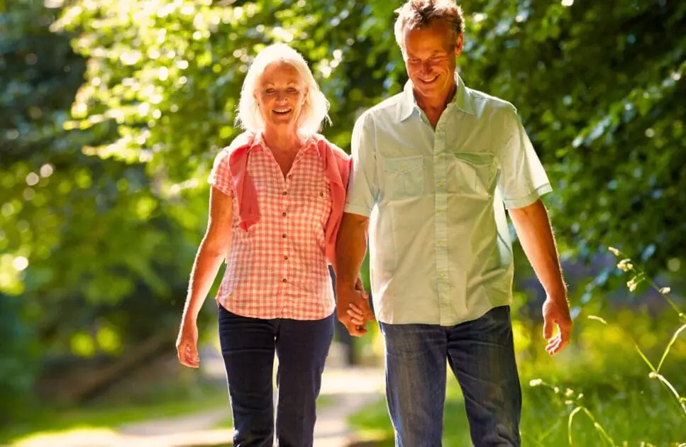 Middle-aged couple walking together on a peaceful park path. Marriage Counselling. Osteopathy for Sciatic Pain and Nerve Irritation. Brisbane Livewell Clinic