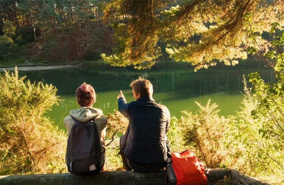 Man and woman sitting on a log while enjoying the peaceful lake view. Hypnotherapy near Clayfield. Brisbane Livewell Clinic. Marriage Counselling Near You in North Brisbane and South Brisbane