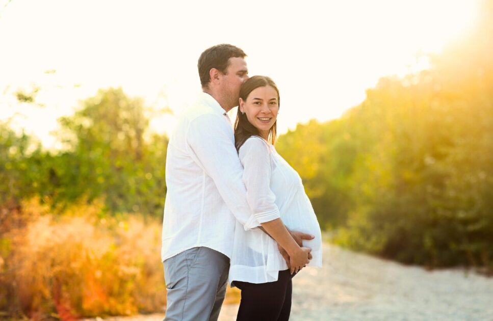 Pregnant woman and her husband standing in the field. Pregnancy and Naturopathy. Brisbane Livewell Clinic