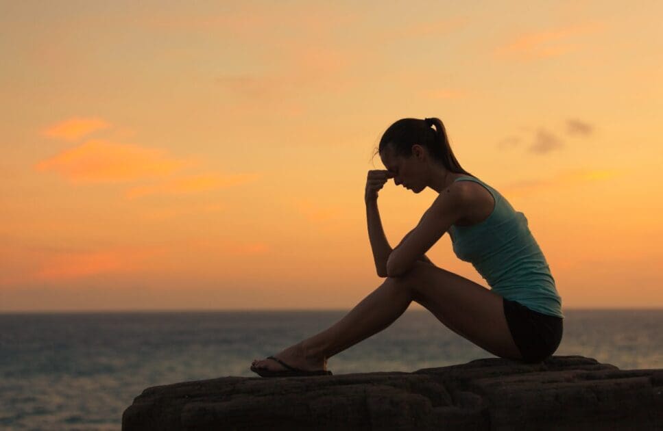 Woman sitting on the rock alone. What is Functional Medicine. Burnout Holistic Counselling. Brisbane Livewell Clinic