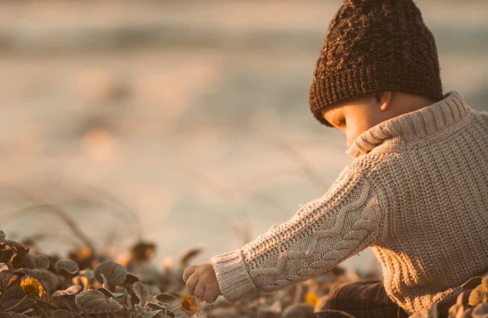 Young child sitting near the shorline. Naturopathic Care for Children. Brisbane Livewell Clinic