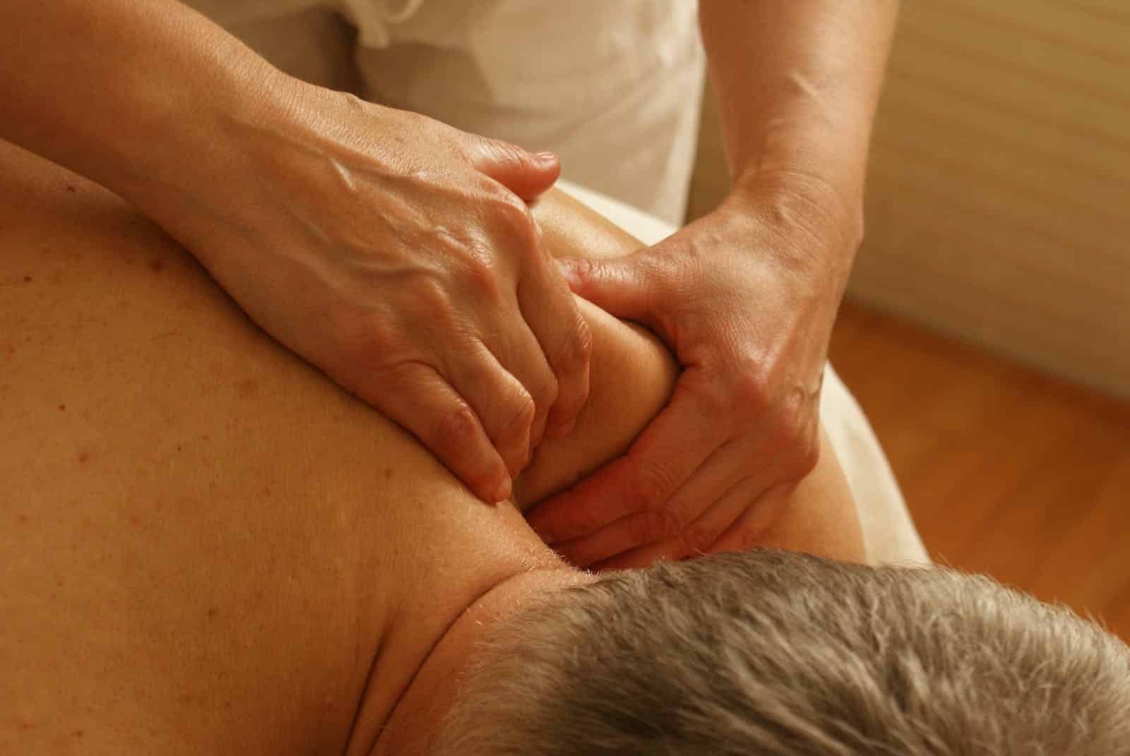 Massage Therapist Massaging Man's Shoulder. Full Body Massage Brisbane.