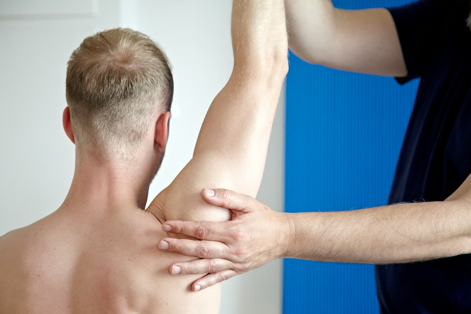 Physiotherapy Brisbane. Man getting his arm examined by a Physiotherapist