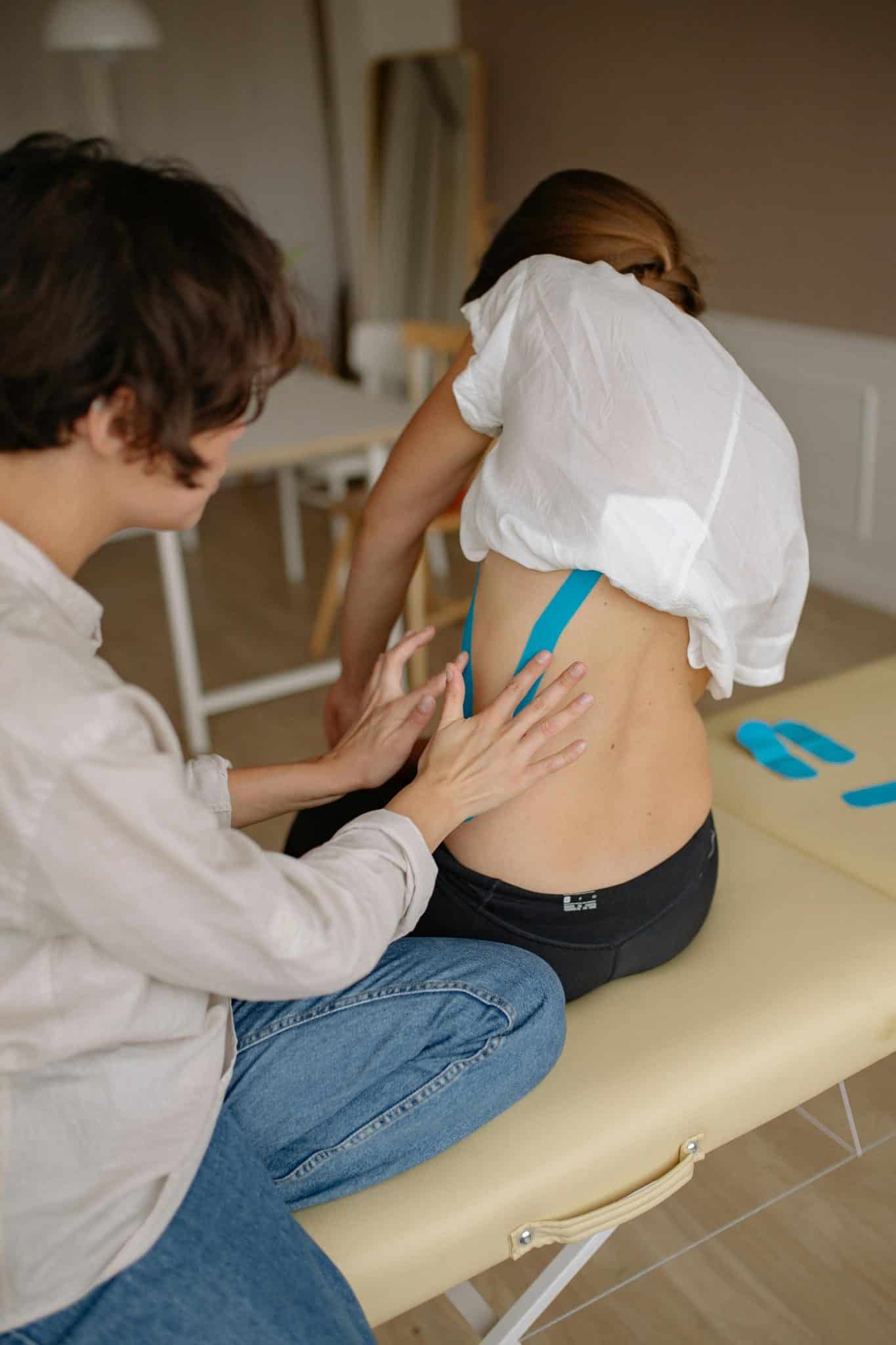 woman putting physio tape on someone's back