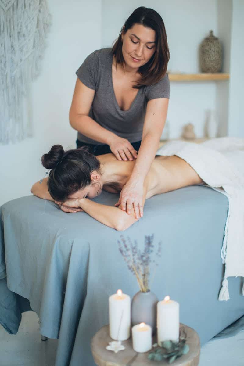 Woman Lying on Bed While Having A Massage. How to choose a massage therapist