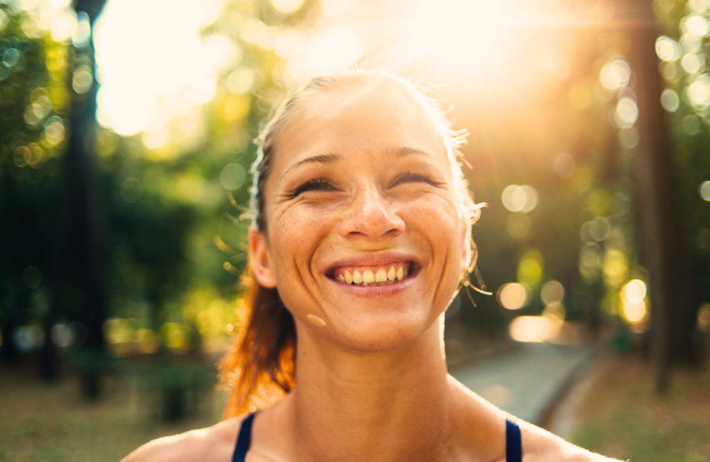 Woman smiles brightly under the sun. Aftermath of Bowen Therapy. Brisbane Livewell Clinic