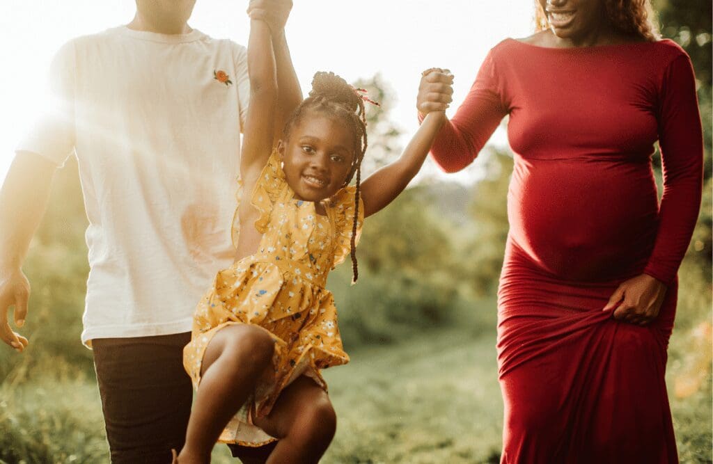 Pregnant mother, father and daughter swinging between them. Methylation Test. Brisbane Livewell Clinic