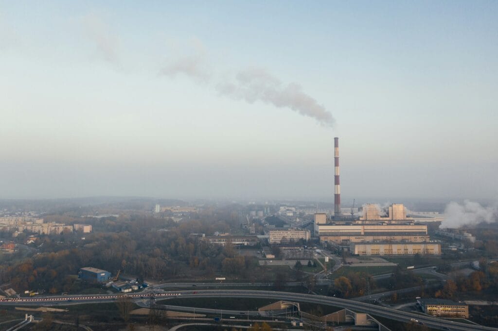City buildings beside a factory smokestack. Heavy Metal and Parasite Detox