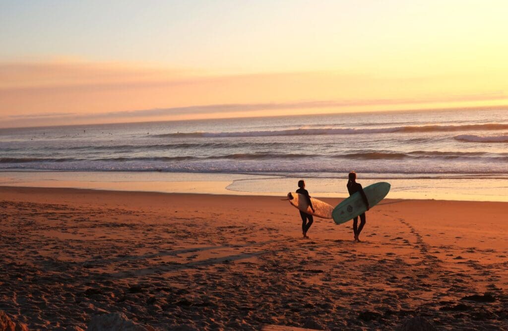 Two surfers walking towards the beach to go surfing. Clinical Hypnotherapy Bulimba. Brisbane Livewell Clinic