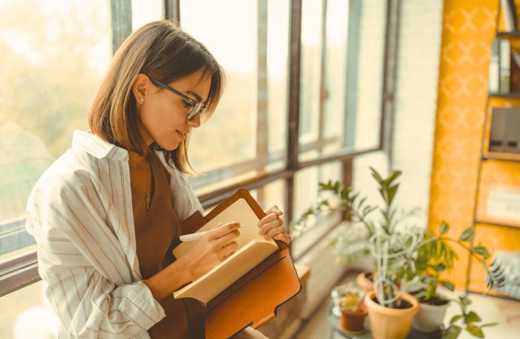 Woman writing positive affirmations in her journal. Hypnosis and weight loss. Brisbane Livewell Clinic