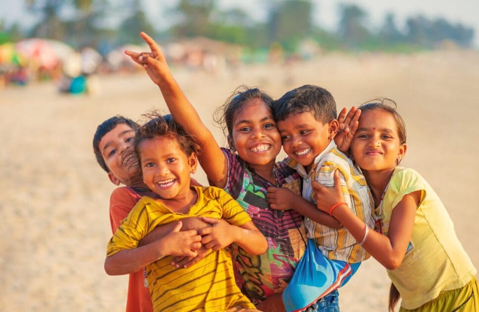 A group of happy children playing on a sandy beach, smiling brightly and embracing each other. Counselling Tingalpa. Brisbane Livewell Clinic. Heavy Metal Detox for Kids