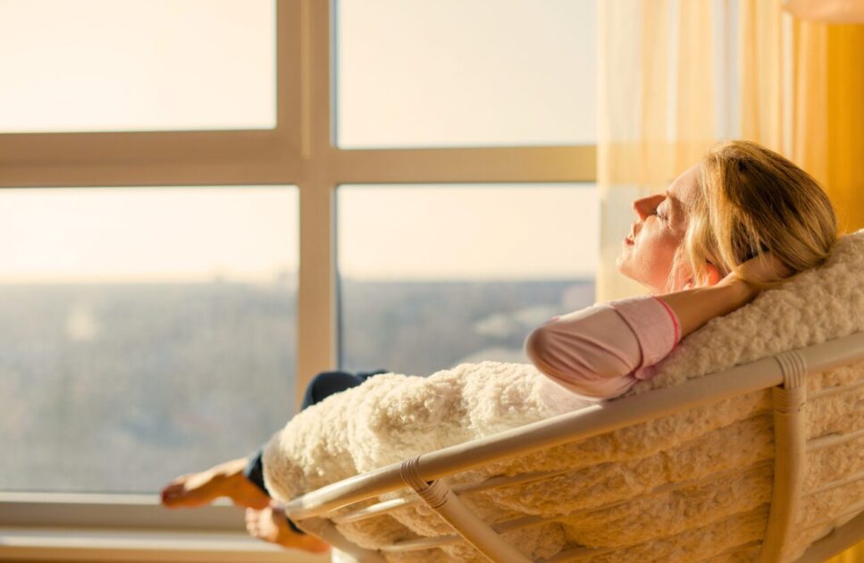 Woman relaxing by the window at home. Reflexology Near Me. Brisbane Livewell Clinic